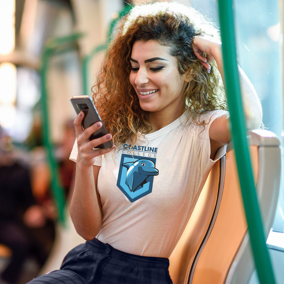 young woman wearing coastline Fin tshirt sitting on bus and using phone